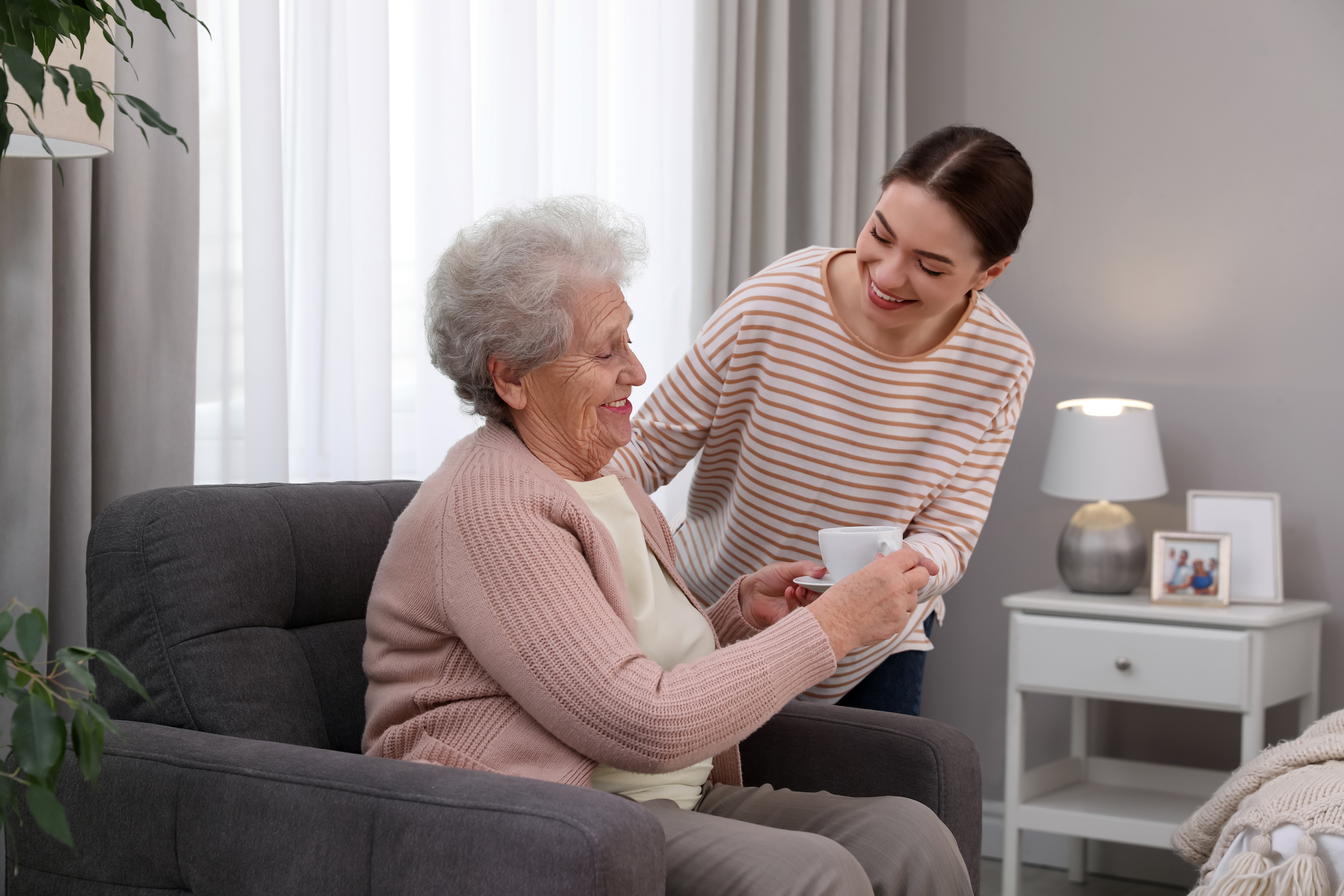 Older adult happily receiving assistance at home.